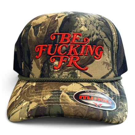 A camouflage trucker hat with orange embroidered text reading 'BE FUCKING FR' on the front, black mesh side panels, and a visible Mikai brand sticker on the brim.
