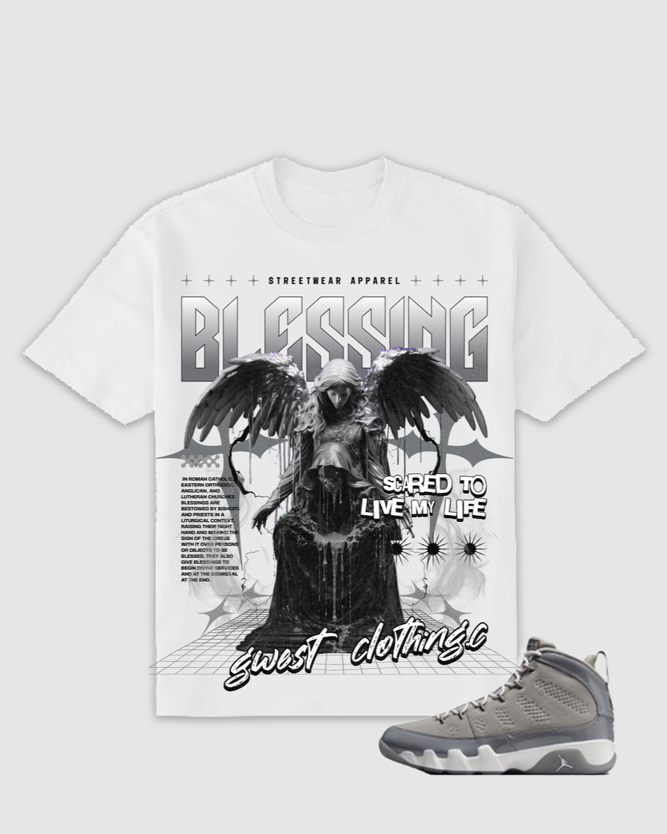 White t-shirt with graphic design featuring a figure and text, paired with a gray sneaker on a light gray background.