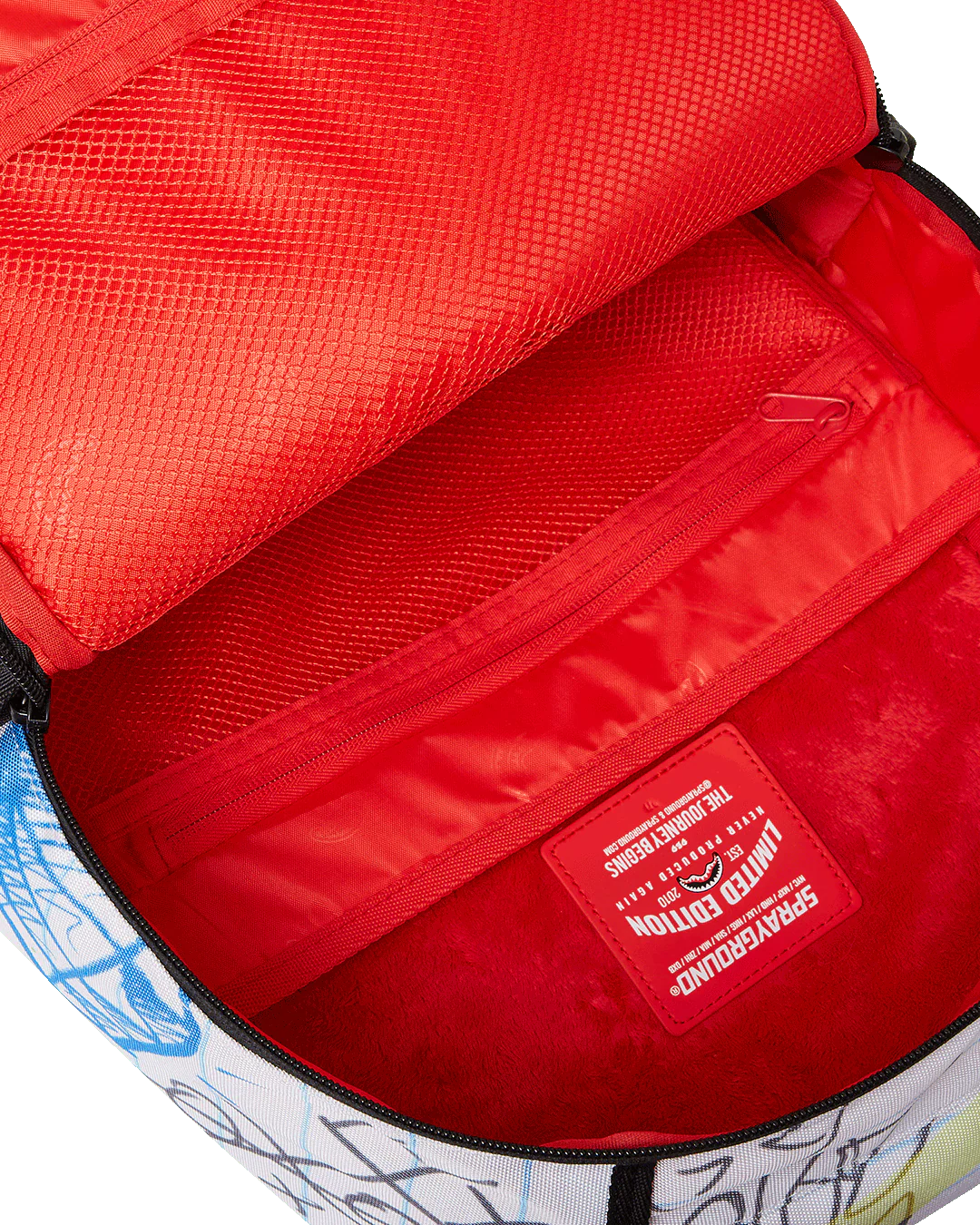 Close-up of a red interior of a bag with a brand label, featuring a colorful design outside.