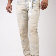 Beige distressed jeans with a brand tag on a white background