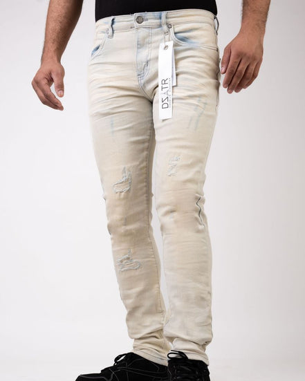 Beige distressed jeans with a brand tag on a white background