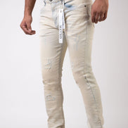 Person wearing light-colored distressed jeans with a visible brand label on a white background