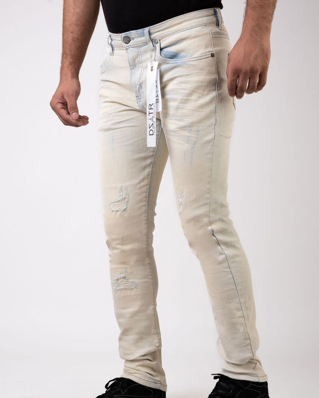 Person wearing light-colored distressed jeans with a visible brand label on a white background