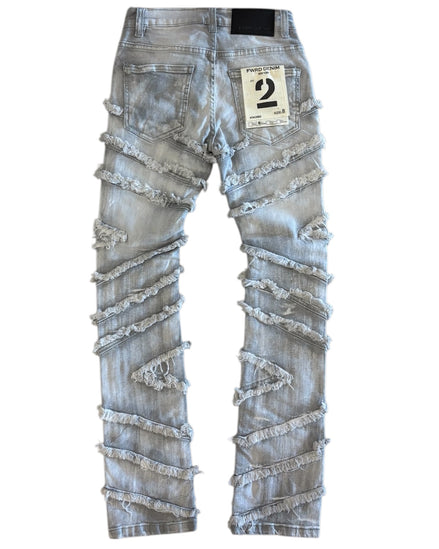 Distressed denim jeans with lace details on a white background