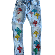 Blue jeans with colorful cross embellishments on a white background