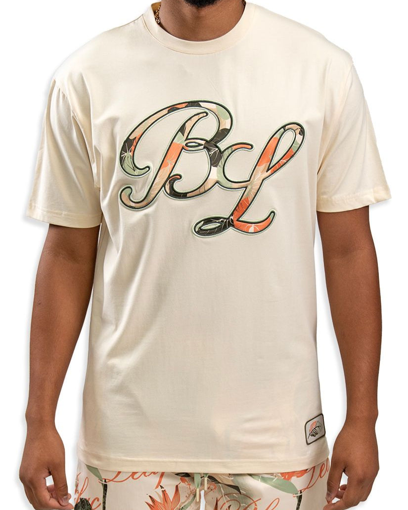 person wearing the leaf arrangement shirt in cream showcasing Blac Leaf's abbreviation in floral print front view