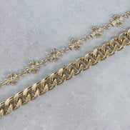 Gold chain with cuban links on a light gray background