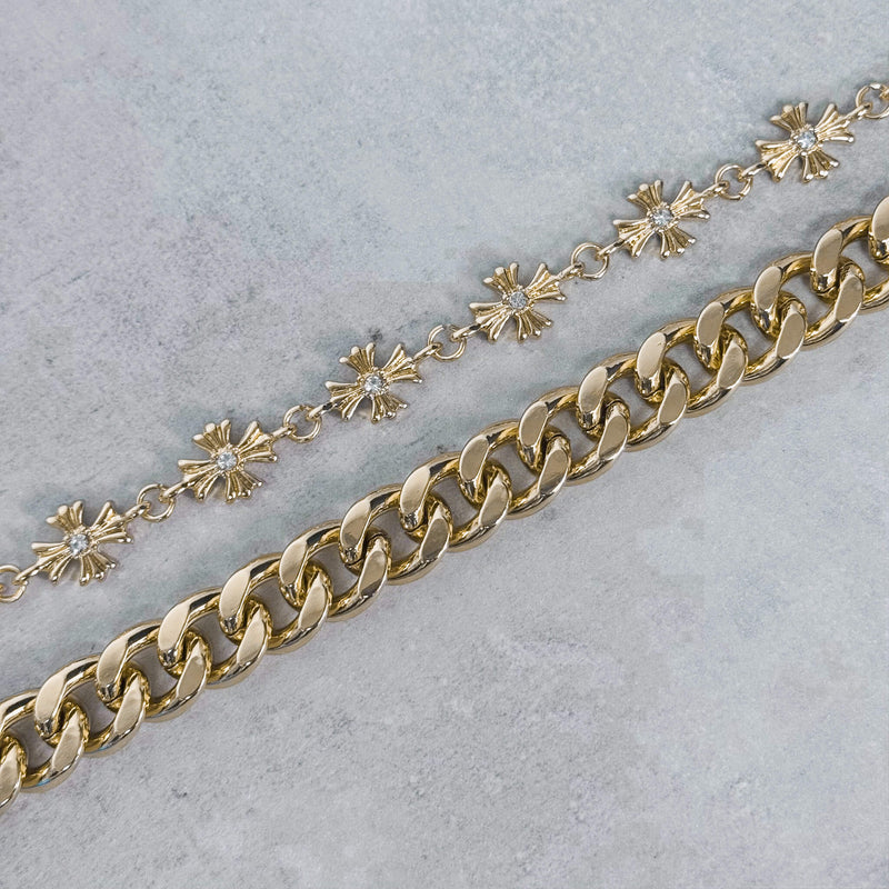 Gold chain with cuban links on a light gray background