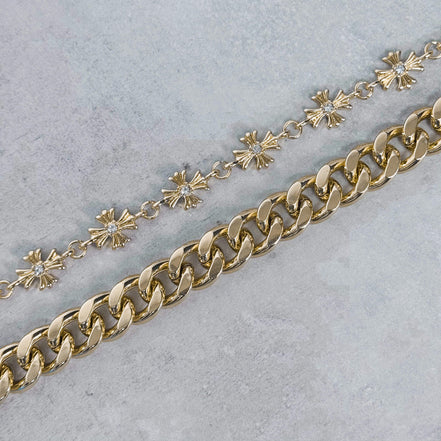 Gold chain with cuban links on a light gray background