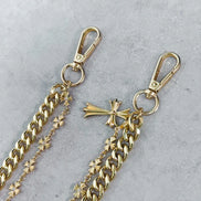 Gold chain with star embellishments and a cross pendant on a gray background