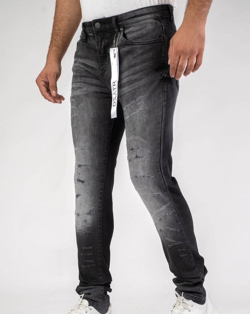 Person wearing black distressed jeans and white sneakers on a white background