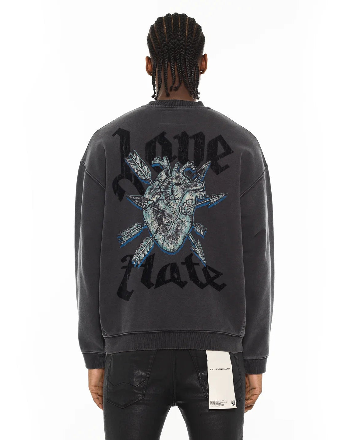 Person wearing a black sweatshirt with a graphic design and text on the back, on a white background