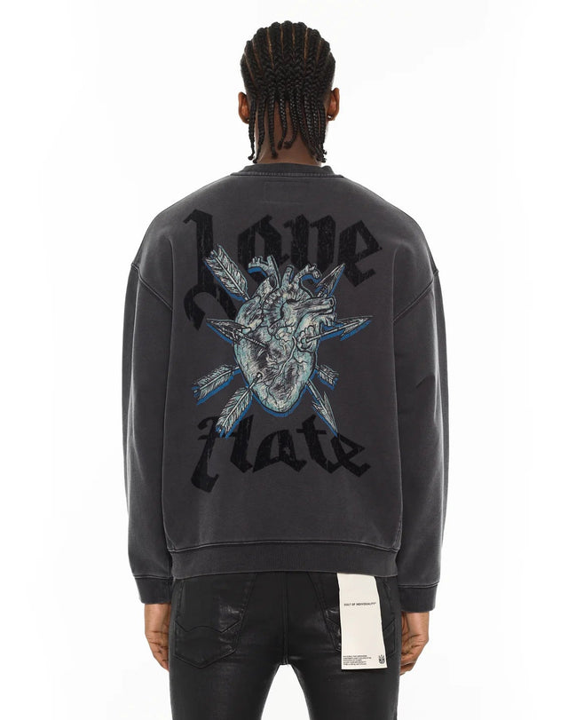 Person wearing a black sweatshirt with a graphic design and text on the back, on a white background