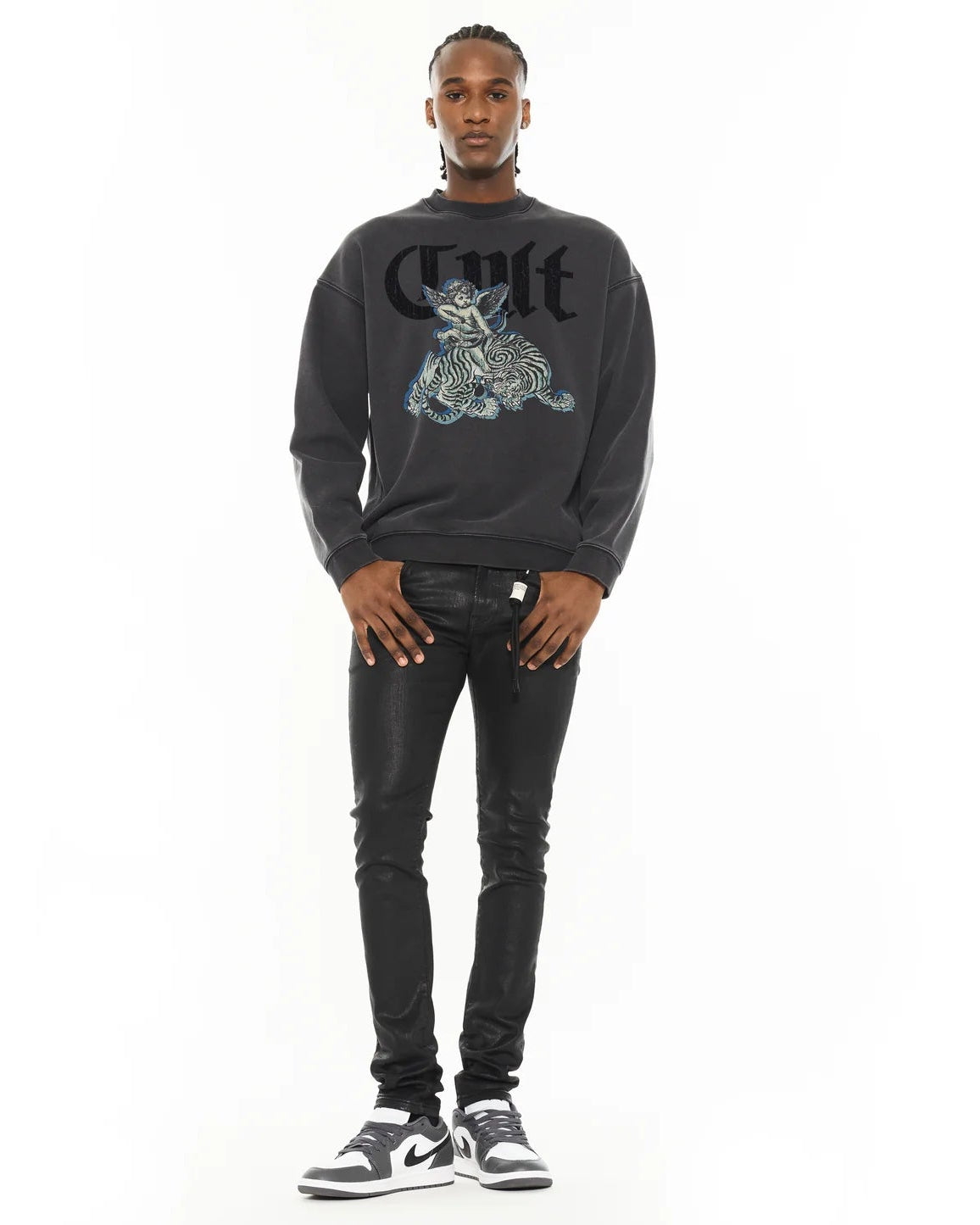 Man wearing a black sweatshirt with graphic design and text, standing against a white background