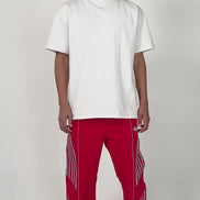 model wearing the red variant of the Roundy pants by brand EPTM. Relaxed posing and energy.