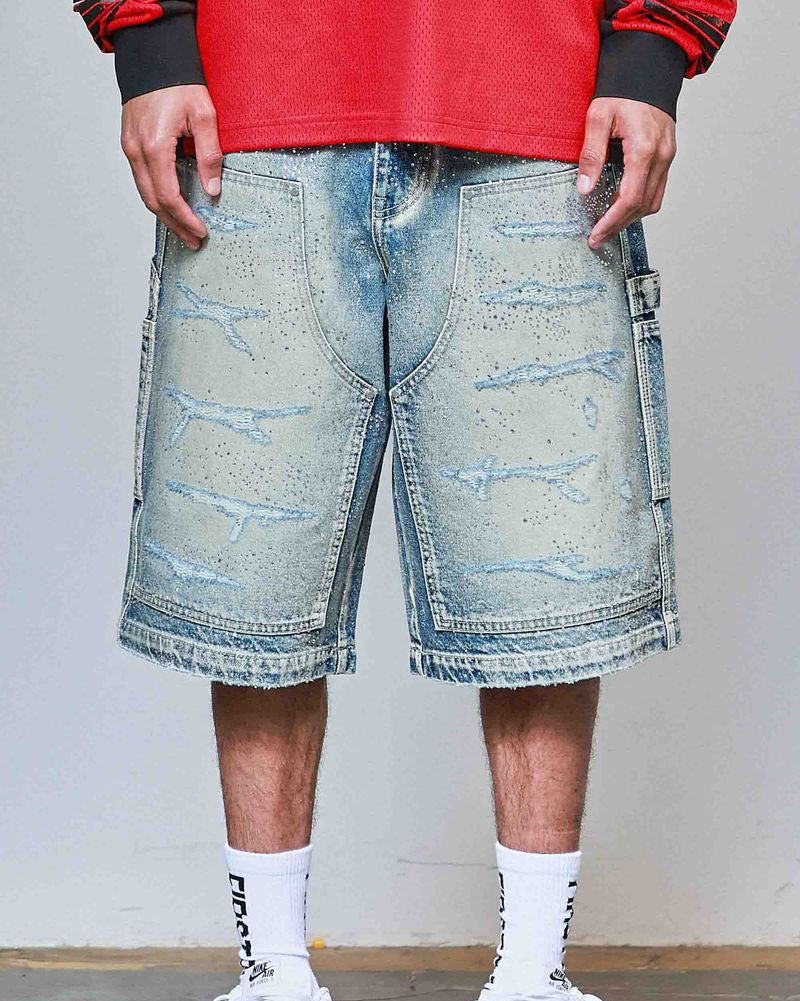 Person wearing light blue denim shorts with a red top and white sneakers on a plain background
