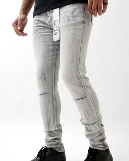 Person wearing light gray jeans with a brand logo on a white background