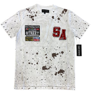 White t-shirt with brown splatter design and visible branding on a white background