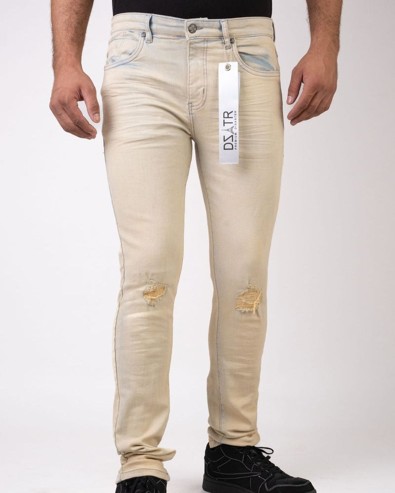 Beige distressed jeans with a brand tag on a white background