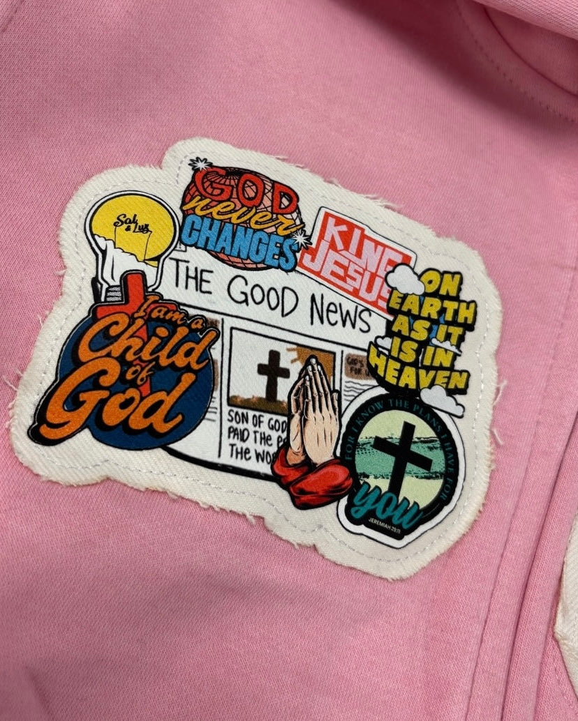 Colorful patch with religious text and graphics on a pink hoodie