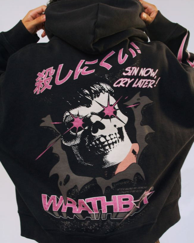 Black hoodie with a graphic design and text on the back, worn by a person.